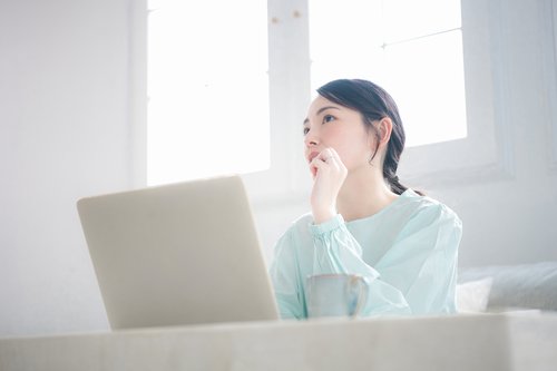 生命保険に加入するべきか悩んでいる若い女性
